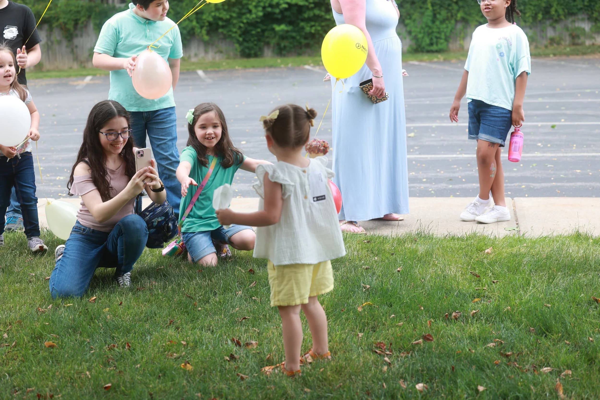 Kids and families playing with balloons outside at a LIFE Kidz event