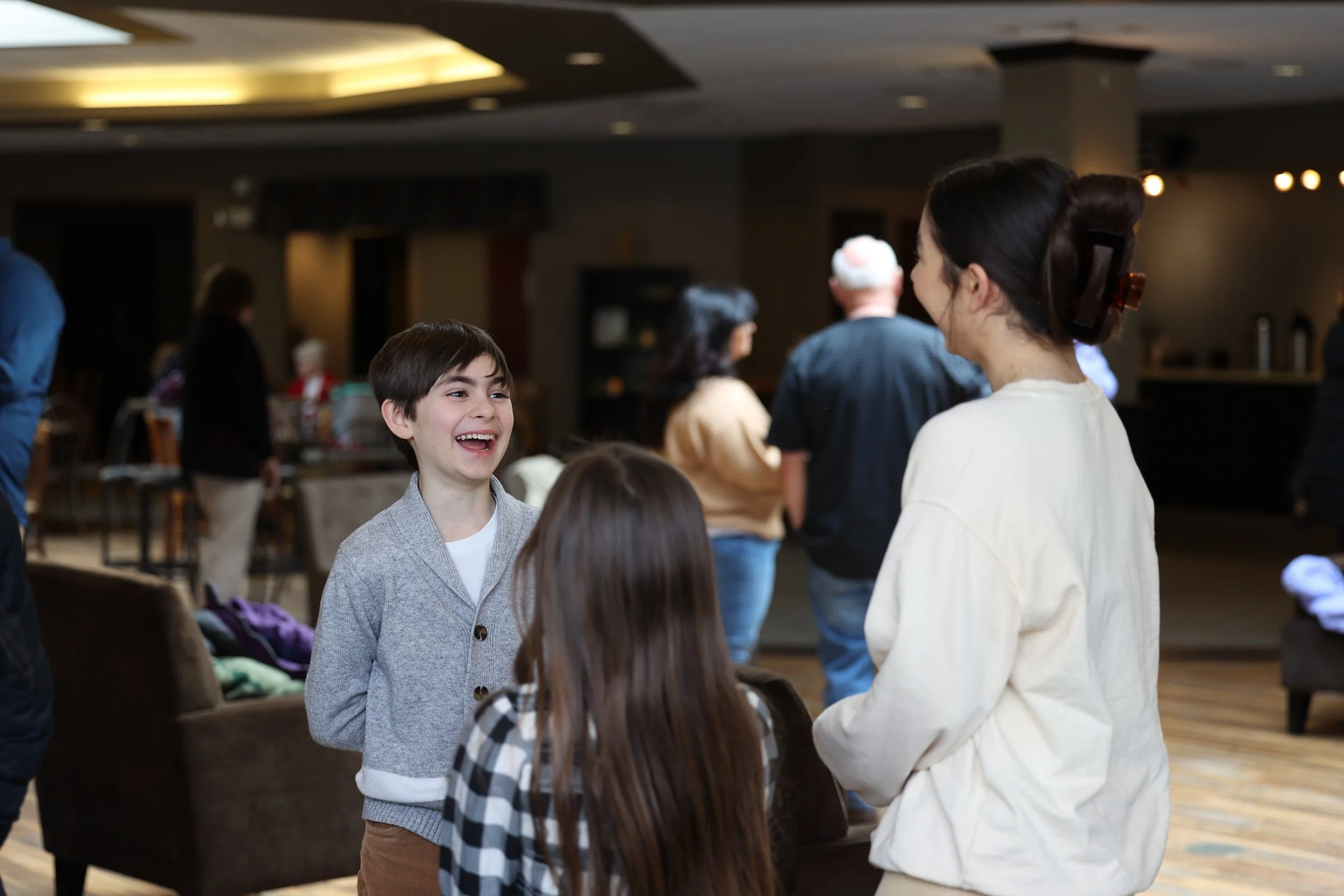 A boy laughing with friends in the church lobby