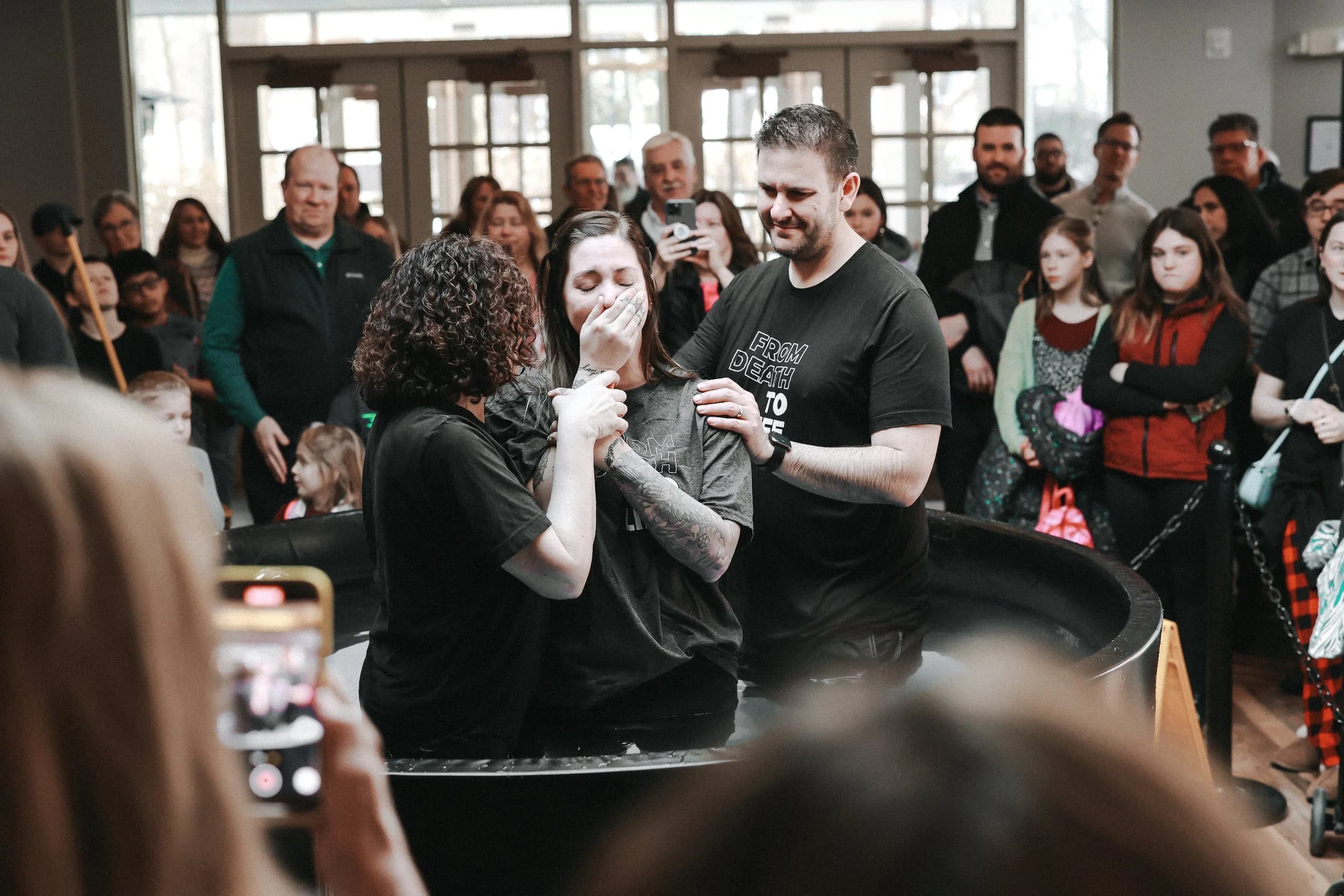 A baptism moment surrounded by church family