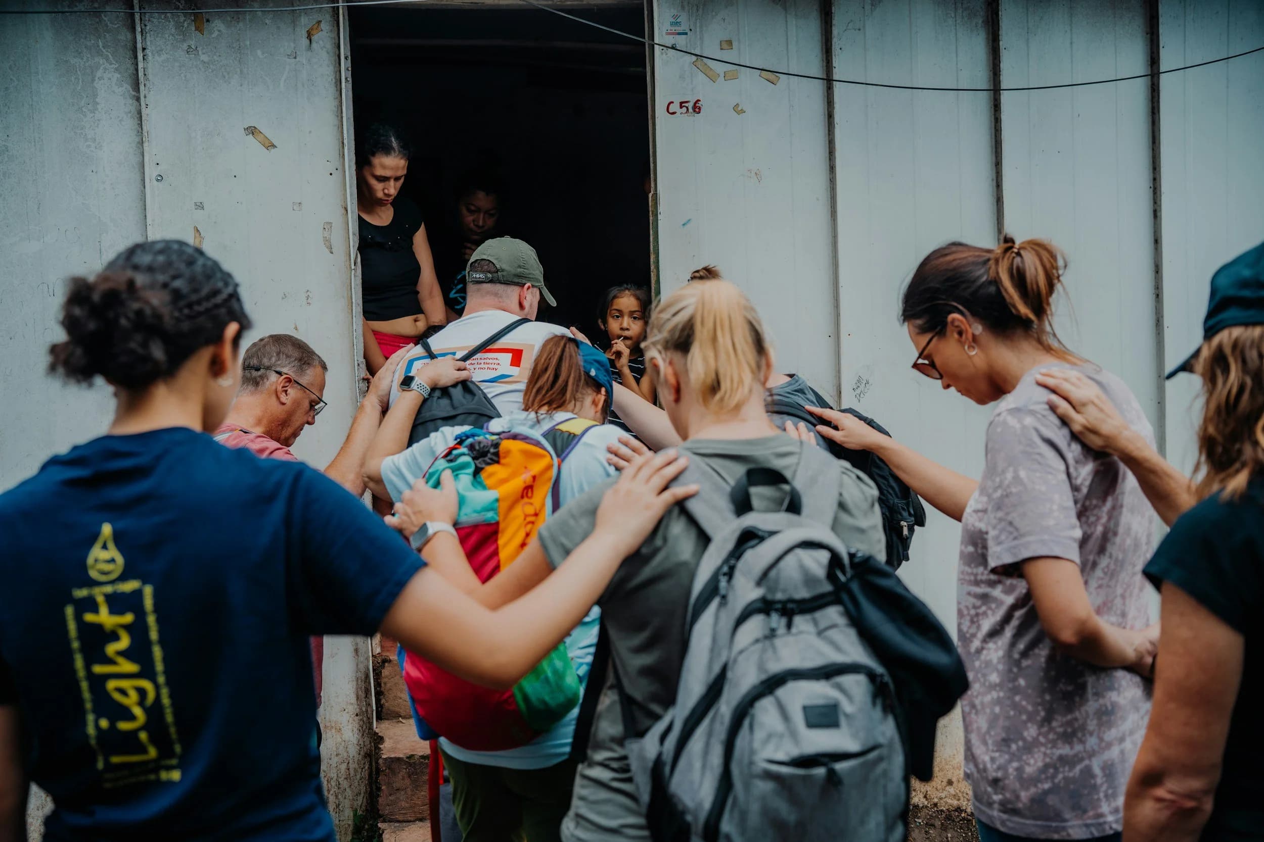 A team praying together with a family during an outreach visit